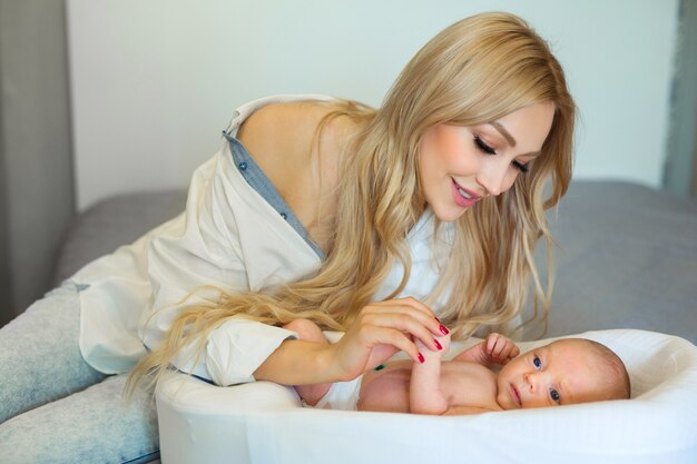 belle jeune mère aux cheveux flottants tenant la main de son jeune enfant