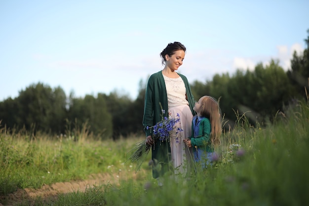 Belle jeune mère avec fille marchant sur une route rurale