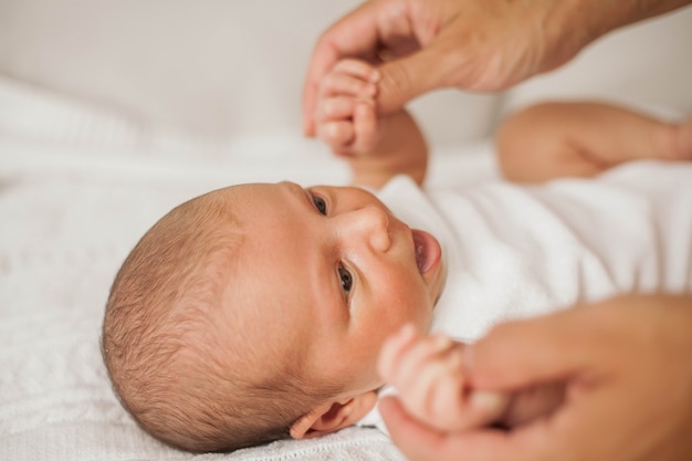 Belle jeune mère joue avec le bébé au lit. Maternité.