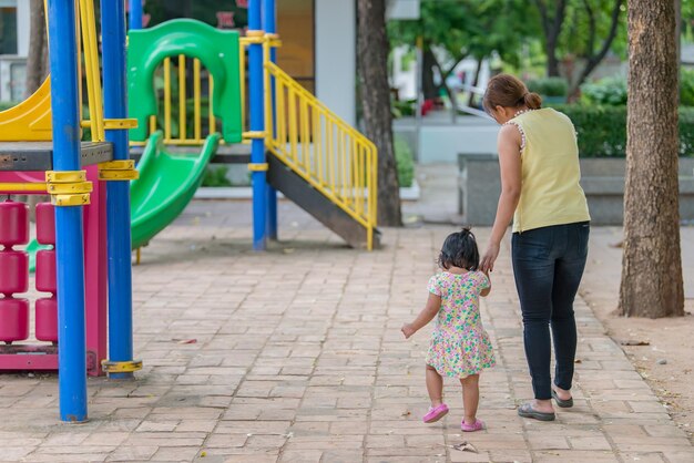 Belle jeune mère joue avec sa fille en s'amusant sur l'aire de jeuxBonne fête des mèresThaïlandais