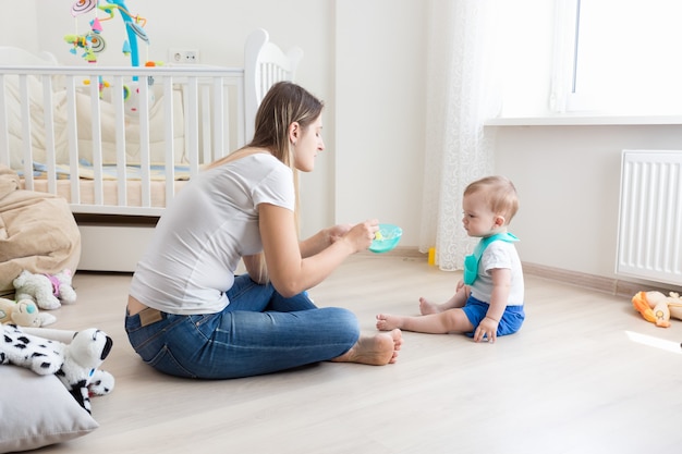 La belle jeune mère prend soin de son enfant en bas âge