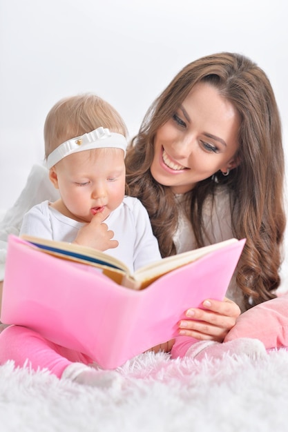Belle jeune mère avec sa fille lisant un livre