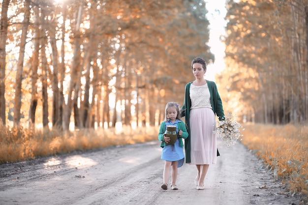 Belle jeune mère avec sa fille marchant sur une route