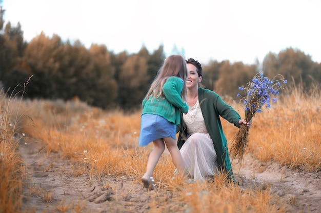 Belle jeune mère avec sa fille marchant sur une route