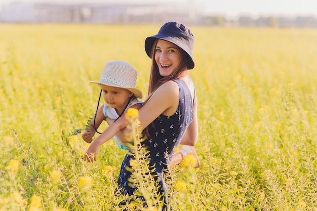 Belle jeune mère et sa fille s'amusant dans le champ de blé.