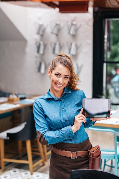 Belle jeune serveuse travaillant dans un restaurant exclusif.