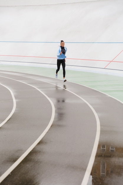 Belle jeune sportive africaine confiante en forme qui court au stade