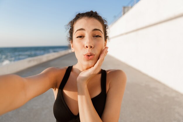 Belle jeune sportive debout à l'extérieur