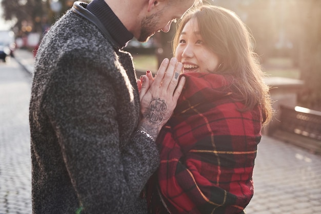 Belle lumière du soleil. Heureux couple multiracial ensemble à l'extérieur de la ville.