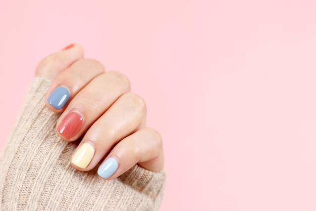 Belle main féminine peignant des ongles en gel acrylique Style de mode Fond rose