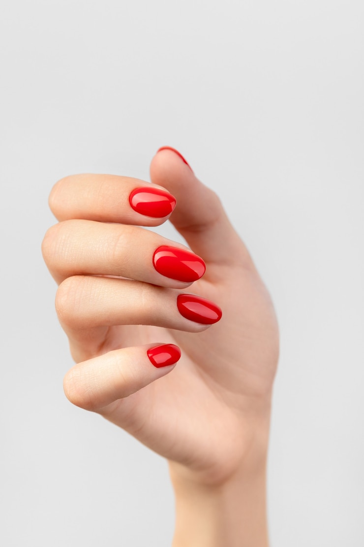 Photo belle main de femme avec manucure rouge sur gris