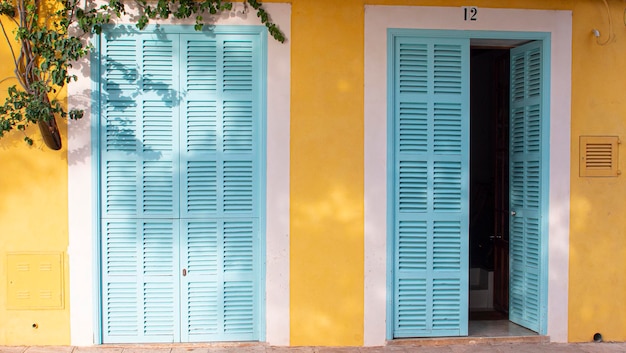 Belle maison avec des portes et des fenêtres de couleur jaune et bleues