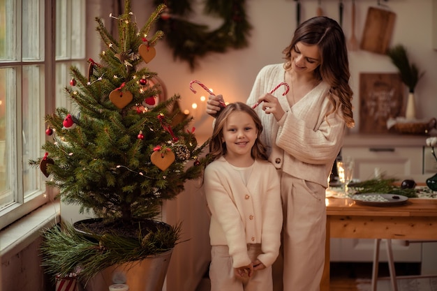 Belle maman et fille près de l'arbre de Noël