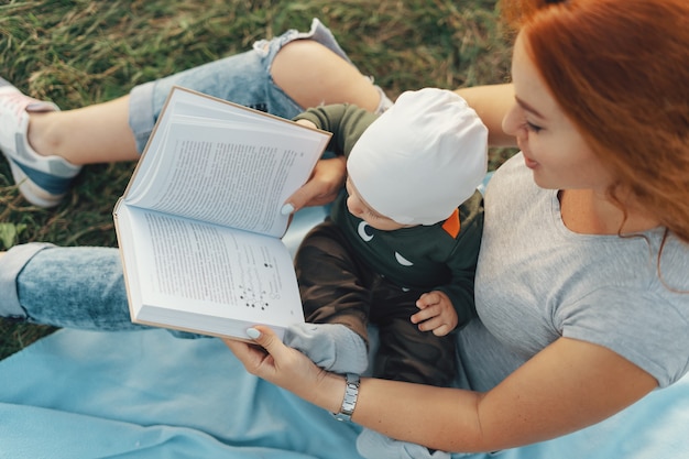 Belle maman lit un livre avec son mignon petit garçon