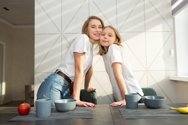 belle maman avec sa fille dans la cuisine à la maison à la table