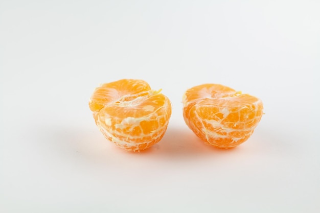 Belle mandarine épluchée mûre sur un fond blanc