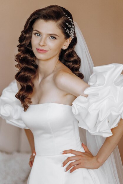 Belle mannequin aux longs cheveux bouclés dans une robe de mariée à la mode Portrait en gros plan vertical