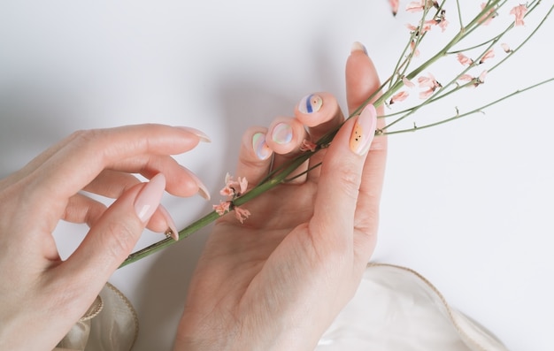 Belle manucure féminine et une branche de fleurs