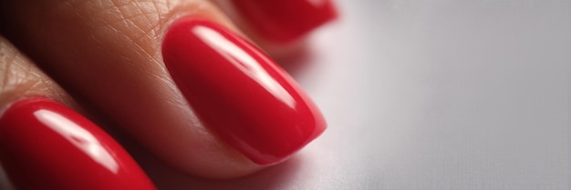 Photo belle manucure en soie rouge sur les ongles féminins