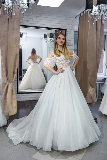 Belle mariée au salon posant en robe de mariée