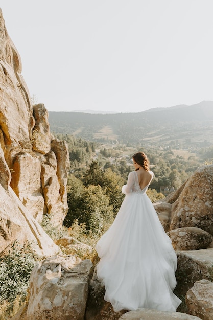 Belle mariée blonde sur fond de montagnes en Italie.