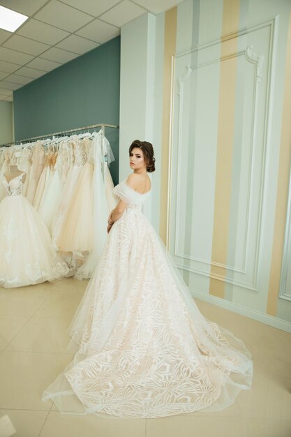 Belle mariée choisissant une robe de mariée dans un salon de mariage