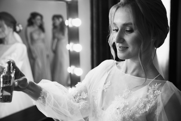 Photo belle mariée avec une coiffure de mariage de mode à l'aide de parfum