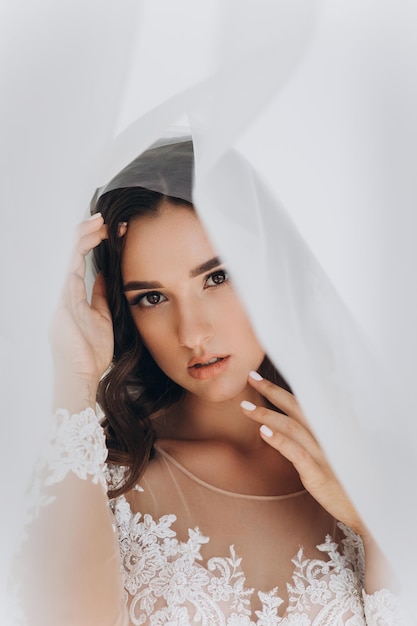 Belle mariée avec une coiffure de mariage de mode - sur fond blanc.