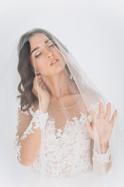 Belle mariée avec une coiffure de mariage de mode - sur fond blanc.