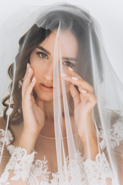 Belle mariée avec une coiffure de mariage de mode - sur fond blanc.