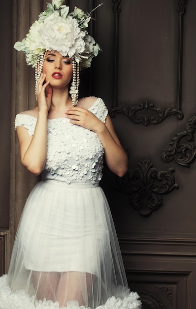 Photo belle mariée dans une robe blanche chapeau et boucles d'oreilles beauté et jeunesse bonheur et innocence