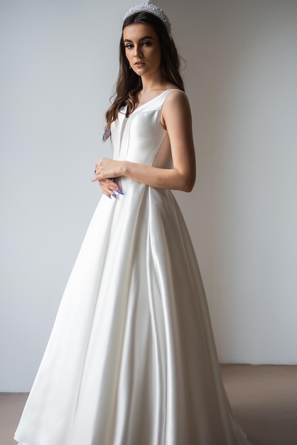 Belle mariée dans une robe de mariée luxueuse sur fond blanc