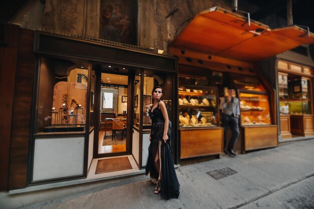 Une belle mariée élégante en robe noire se promène dans Florence, un modèle en robe noire dans la vieille ville d'Italie