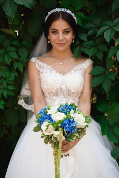 Belle mariée à l'extérieur dans une forêt, le jour du mariage.