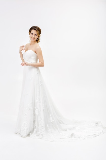 Belle mariée heureuse en robe de mariée sur fond blanc