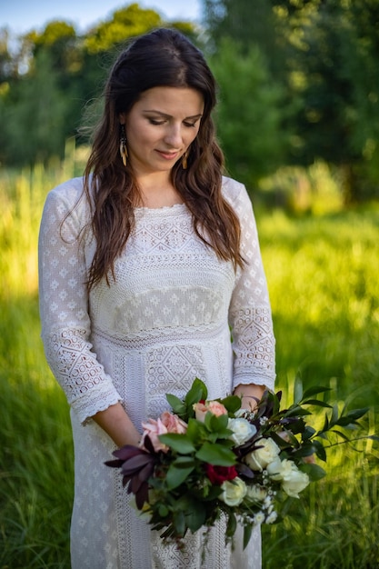 Belle mariée jour de mariage à l'extérieur heureuse jeune femme avec bouquet de fleurs de mariage