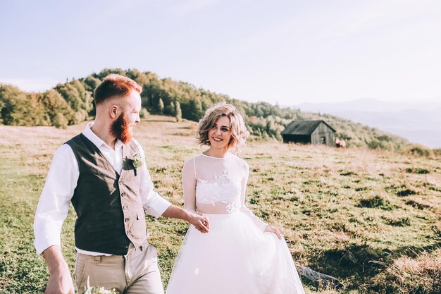 Belle mariée magnifique posant pour se toiletter et s'amuser, cérémonie de luxe à la montagne