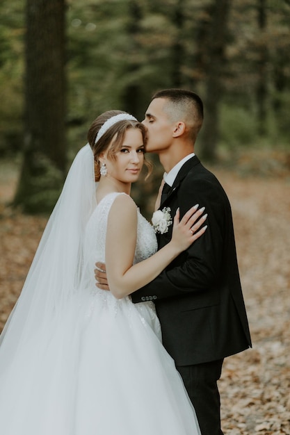 Belle mariée et le marié au coucher du soleil dans la nature verdoyante.