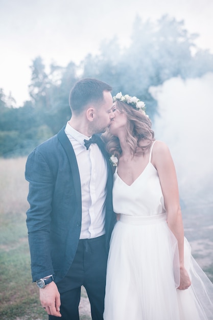 Belle mariée et le marié avec des bombes de fumée.