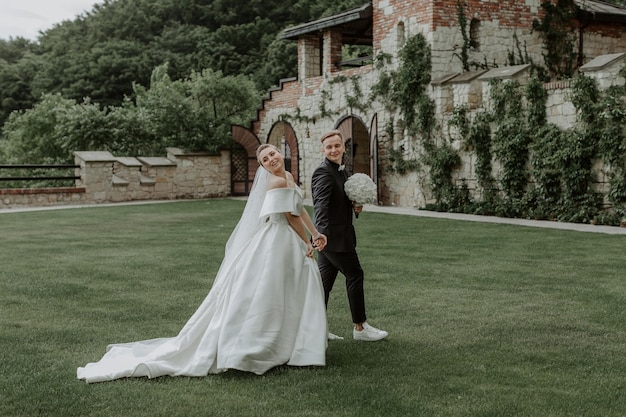 Belle mariée et le marié embrassant et s'embrassant le jour de leur mariage en plein air