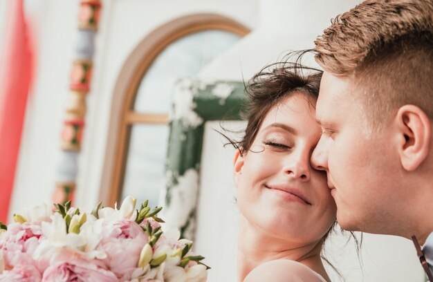 Belle mariée et le marié étreignant et s'embrassant le jour de leur mariage