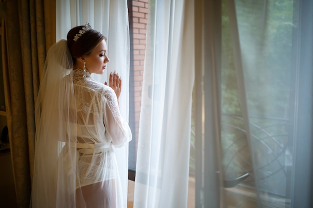 Belle mariée un matin de mariage en peignoir et voile