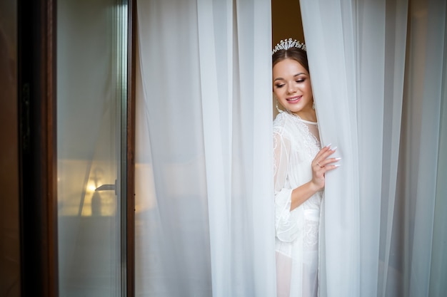 Belle mariée un matin de mariage en peignoir et voile