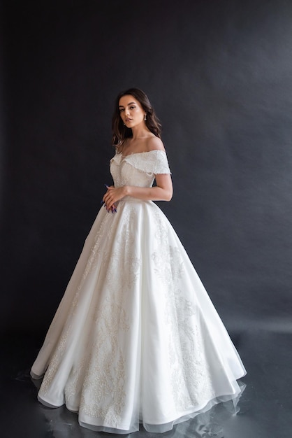 Belle mariée portant une robe de mariée dans un intérieur sombre