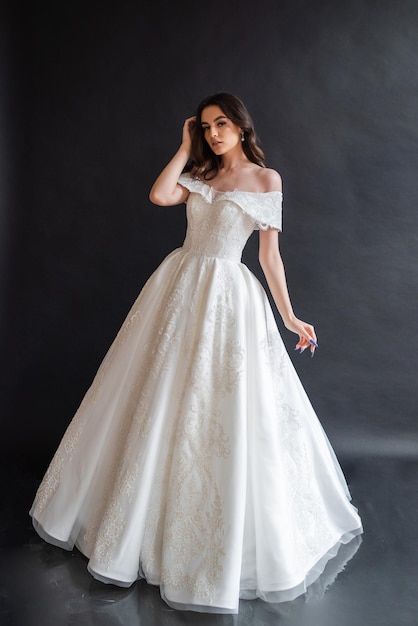 Belle mariée portant une robe de mariée dans un intérieur sombre