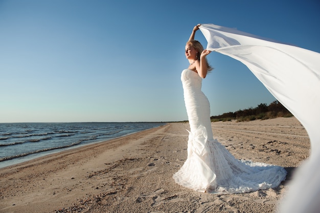 Belle mariée posant sur une côte de la mer