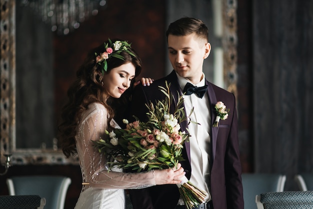 Belle mariée en robe blanche avec bouquet de mariée et beau marié