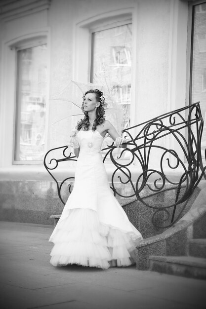 Photo belle mariée en robe blanche avec parapluie