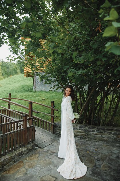 Belle mariée en robe de mariée fashion sur fond naturel.