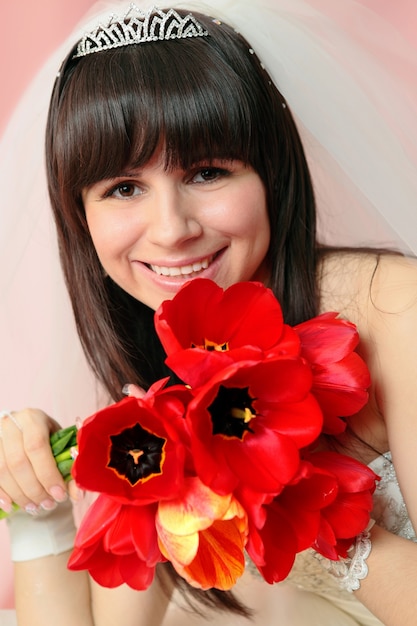 Belle Mariée Souriante Avec Le Bouquet De Tulipes Rouges